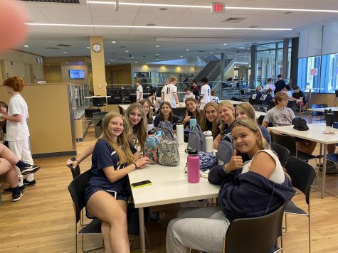 A group of freshmen pose while eating lunch