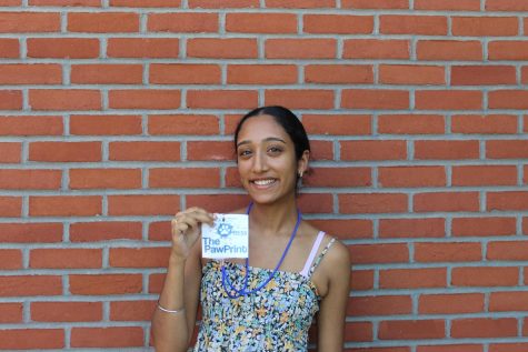 student poses with pawprint necklace