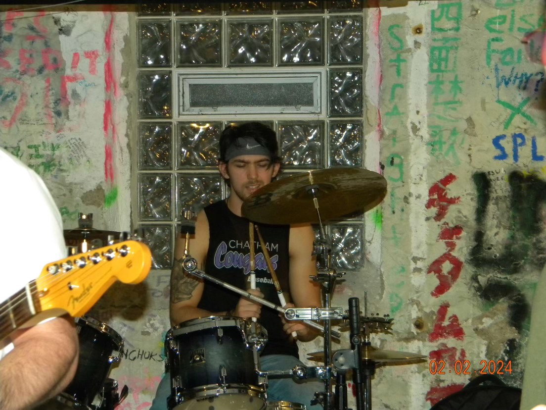 Ryan playing drums at a show