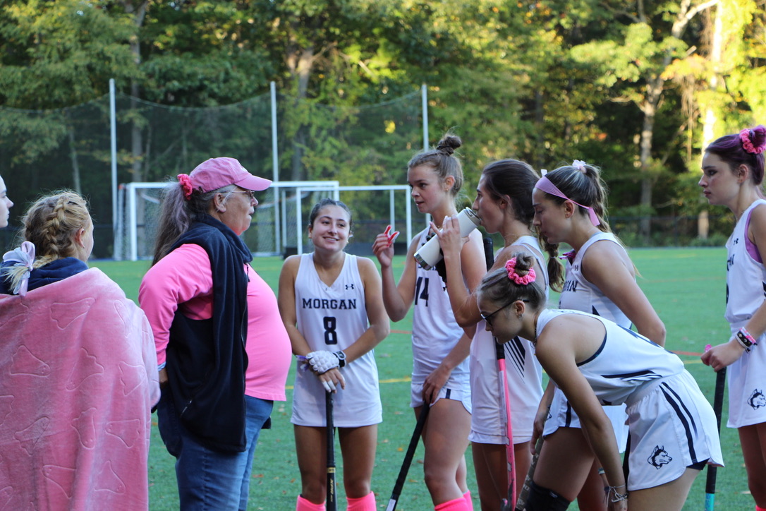 Coach Powers discussing gameplay with the team during a time out during the pink game.