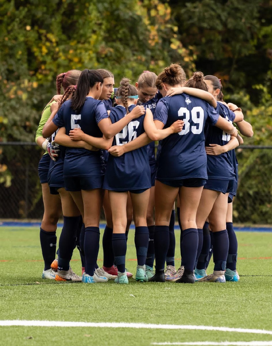 Girls soccer in a huddle before a game