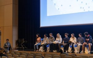 Students on stage listening to Mr. Bergman