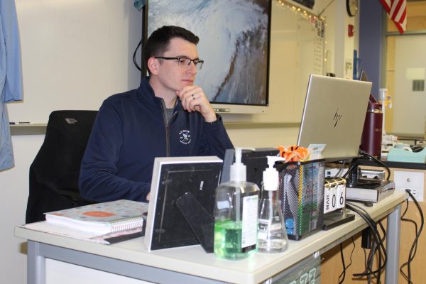 Mr. Rowe sitting at his desk, working on course work for Meteorology.