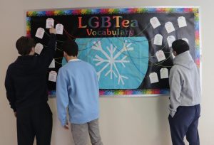 Morgan students looking at LGBTea Vocabulary Bulletin Board