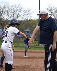 Coach Marsh high fiving Laura Orn on third 