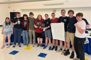 The Trivia Bowl Team standing in a line showcasing their rewards for competing in and winning the shoreline championships.