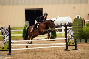 Ava Nettleton jumping with a horse