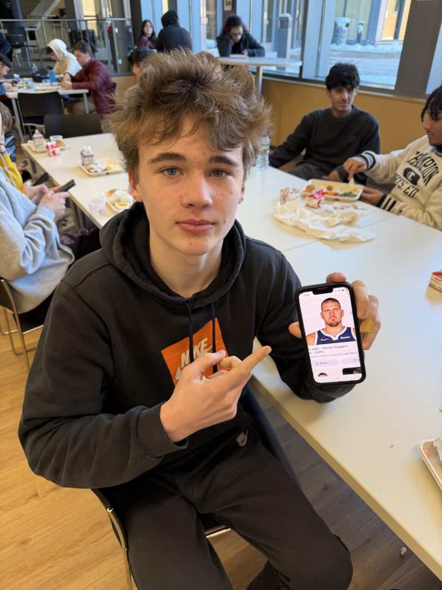 Senior basketball captain Dylan Cinquinto showing a photo of an NBA player
