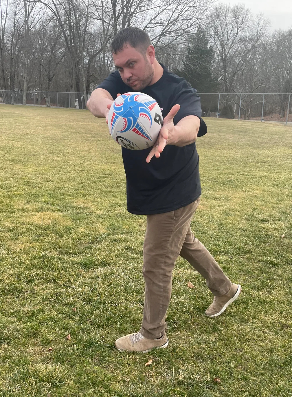 Coach Jake Dilts throwing a rugby ball
