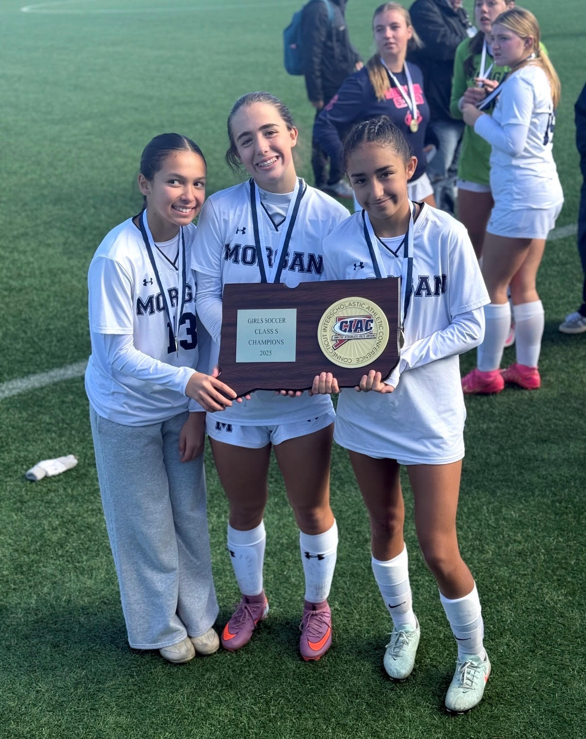 Photo of Addy Massey, Colbie LeClaire, and Katelyn Ramirez holding the State Title plaque.